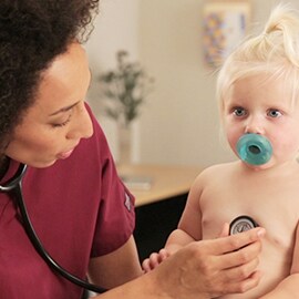 Pediatrische verpleegkundige luistert naar de borst van een peuter met een 3M Littmann Classic III Stethoscope. 