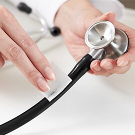 Met de hand reinigen van de buizen van een Littmann stethoscoop met een alcoholdoekje.